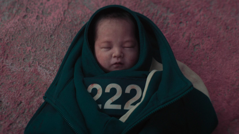 The baby wrapped up in a player jacket in Squid Game Season 3