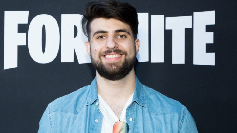 SypherPK in front of Fortnite sign