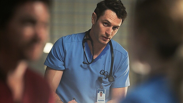 Xander Phillips dressed in scrubs and staring in "Pulse"