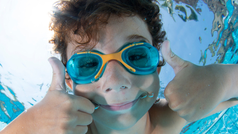 Kid wearing goggles swimming