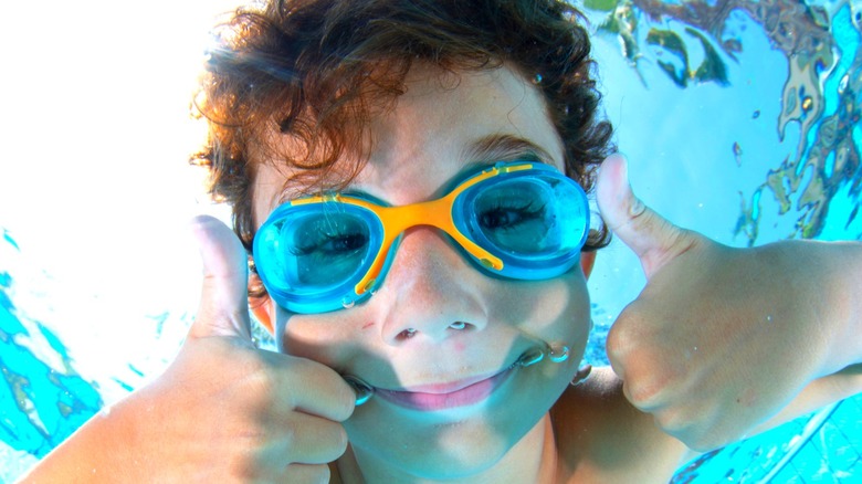 Kid wearing goggles swimming