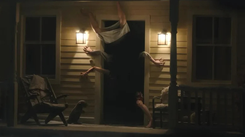 A mass of limbs emerging through a door in Resident Evil
