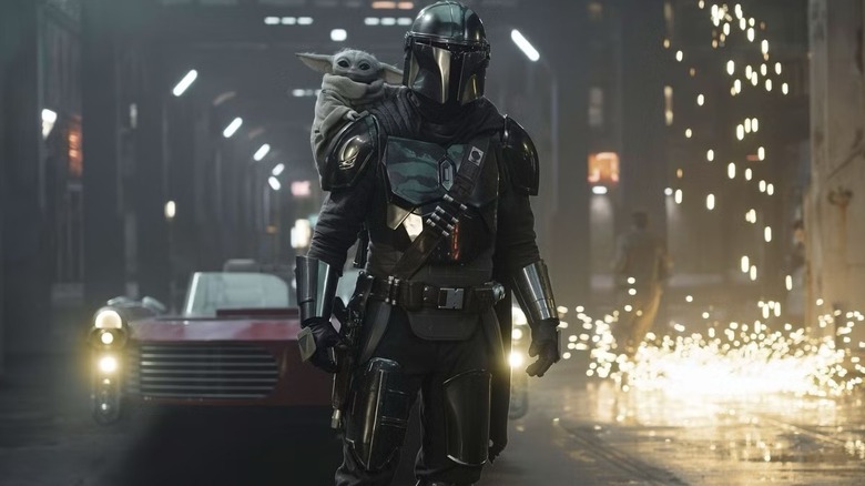 The Mandalorian and Grogu stand on a grungy city street in "The Mandalorian and Grogu" (2026)