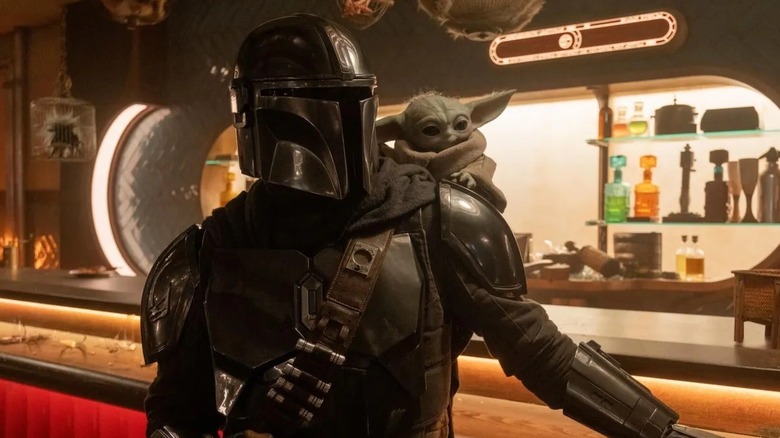 The Mandalorian and Grogu standing beside a shattered bar in "The Mandalorian and Grogu" (2026)