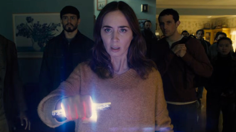 Margaret looking horrified holding a glowing object in Disclosure Day