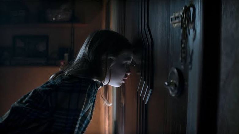 Kid looks through a peephole in Evil Dead Rise