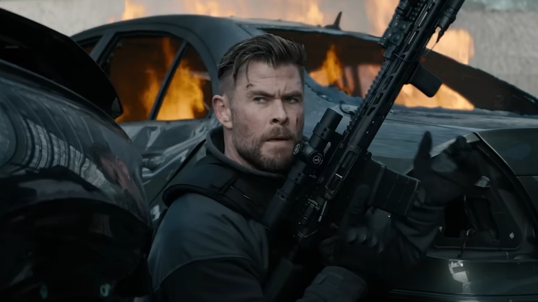 Tyler Rake holds a rifle in "Extraction 2" (2023)