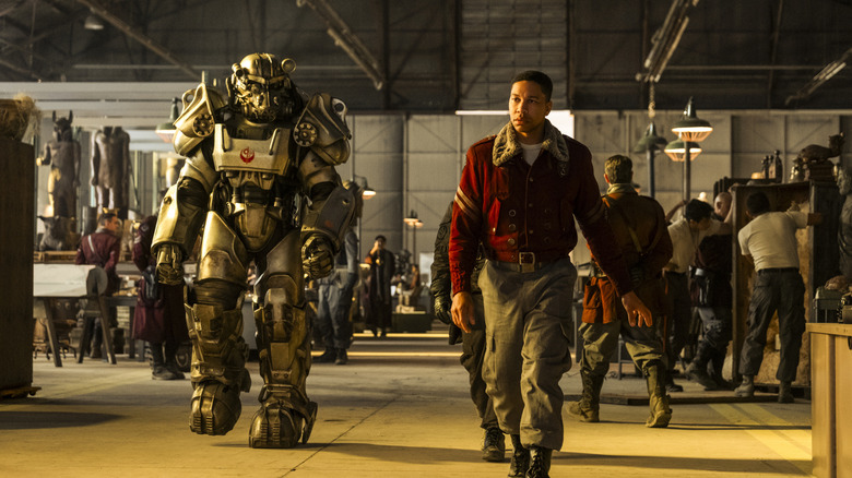 Maximus and a soldier in power armor walking through barracks in "Fallout" Season 2