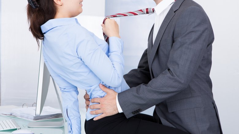A woman and a man about to have sex on an office desk