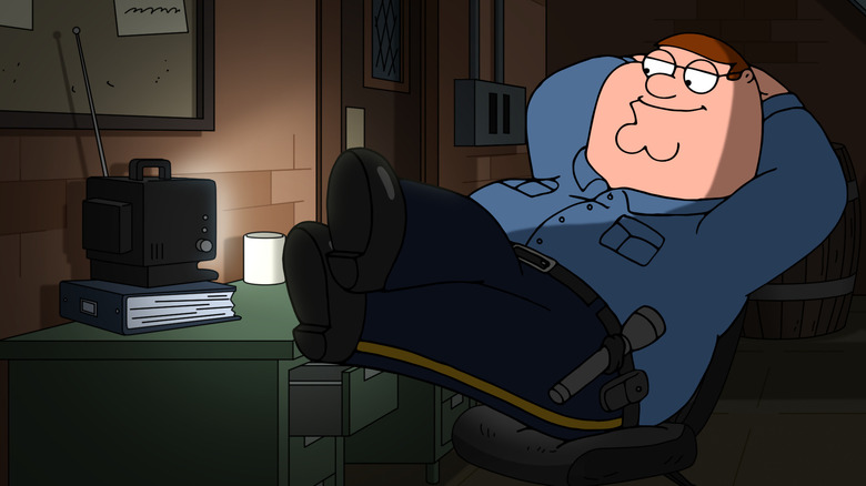 Peter Griffin in blue security uniform sitting watching TV