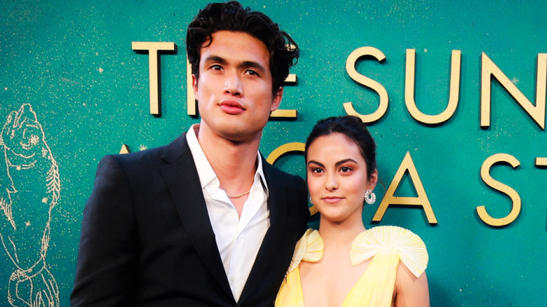 Camila Mendes and Charles Melton stand close