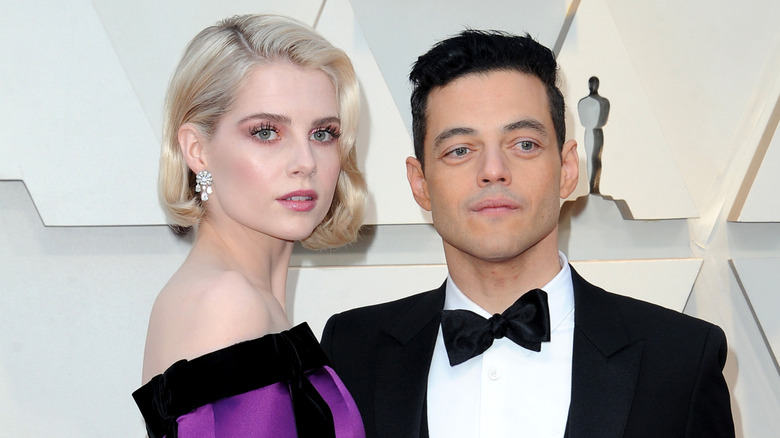 Lucy Boynton and Rami Malek stand together