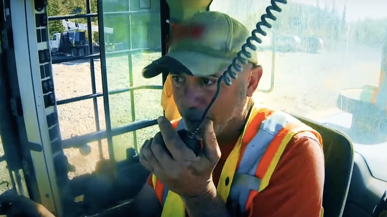 Chris Doumitt smoking and looking at equipment 