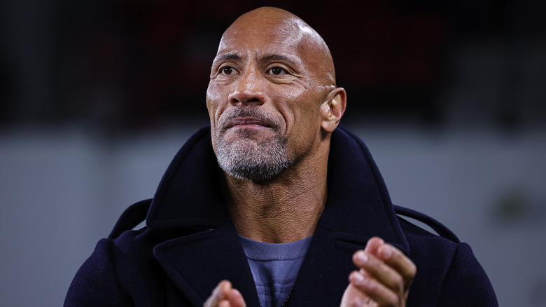 Dwayne Johnson clapping at an XFL game