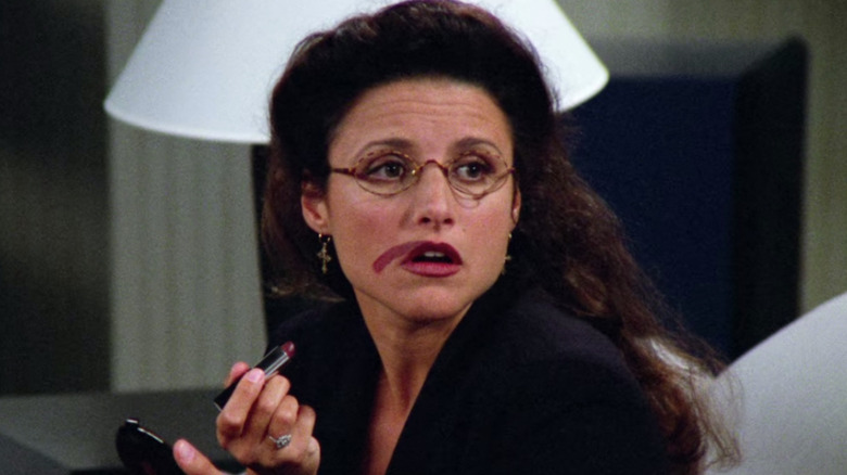 Elaine putting on lipstick