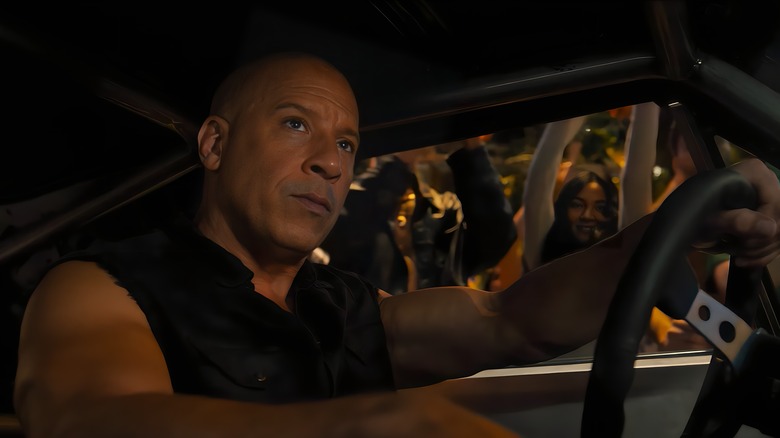 Dominic Toretto driving with his hands on the steering wheel