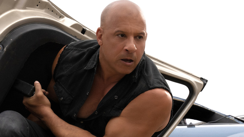 Vin Diesel holds a car door