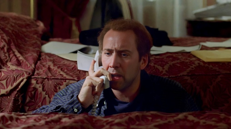 Charlie Kaufman holds a phone receiver