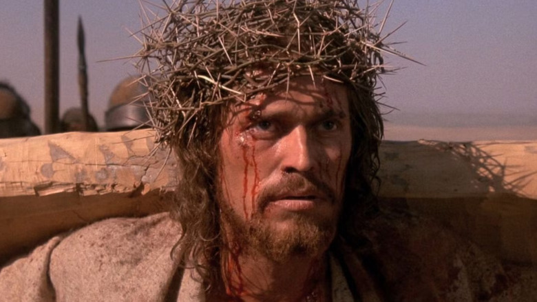 Jesus carries the cross, wearing a crown of thorns, in "The Last Temptation of Christ" (1988)