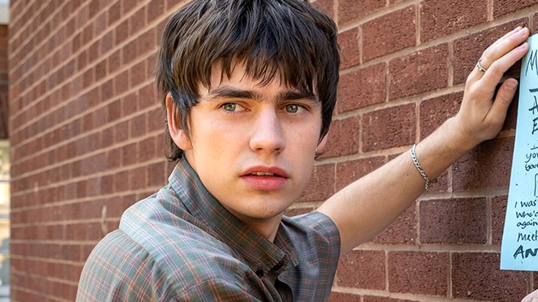 Owen putting up a poster in Finding Emily (2026)