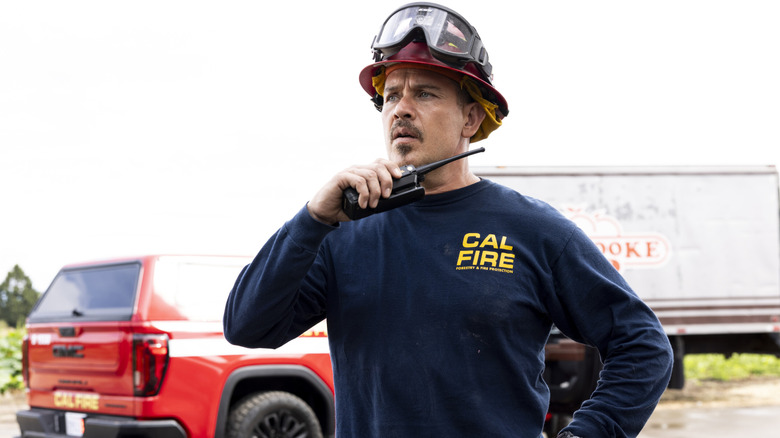 Manny stands commandingly before a truck in 