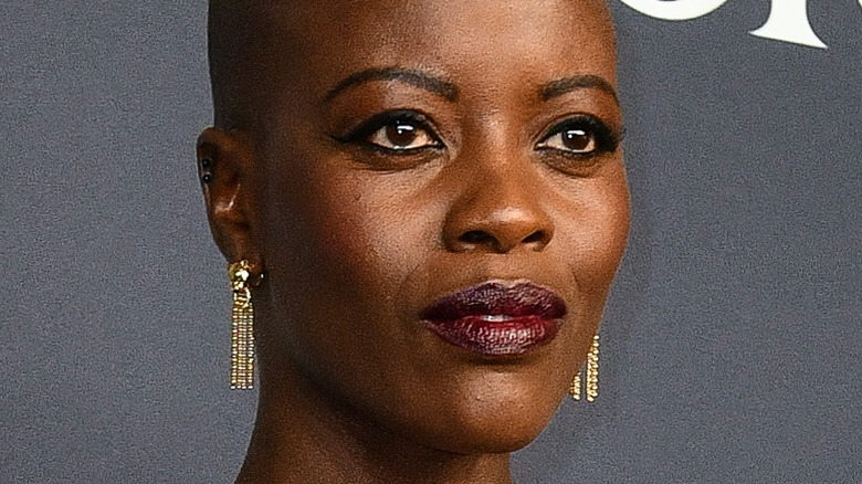 Florence Kasumba wearing gold earrings