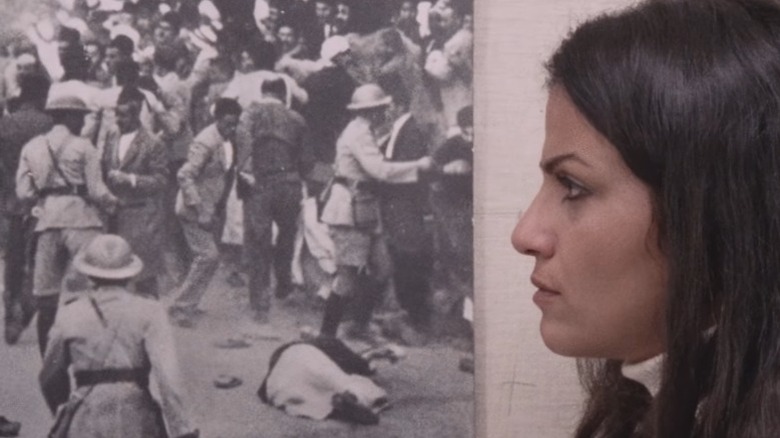 Leila standing next to a picture on the wall in Leila and the Wolves