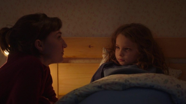 Marion kneeling next to Nelly in bed in Petite Maman