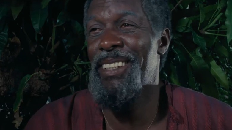 Siméon smiling in front of leaves in Siméon