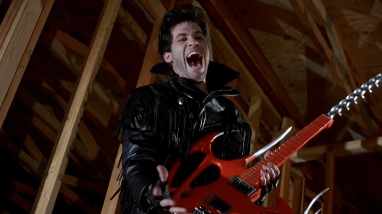 The Driller Killer holding his electric guitar-powered drill and laughing evilly in "Slumber Party Massacre II"