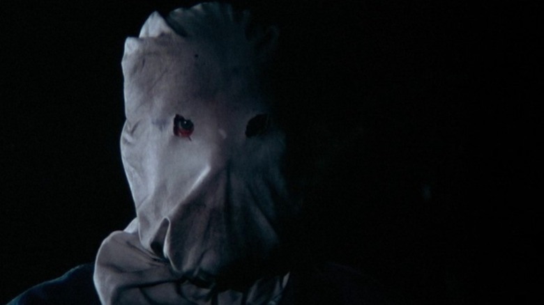A close-up of the Phantom Killer in his burlap mask with one eye visible in "The Town That Dreaded Sundown"