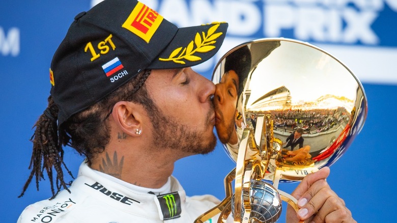 Racecar driver kissing a trophy