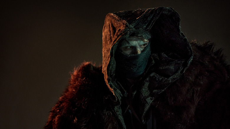 The creature wears a fur coat and mask in "Frankenstein" (2025)