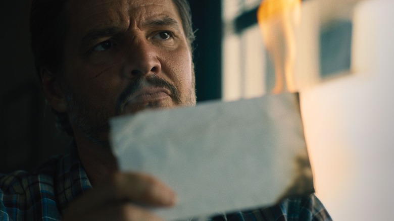 Clint holding burning envelope