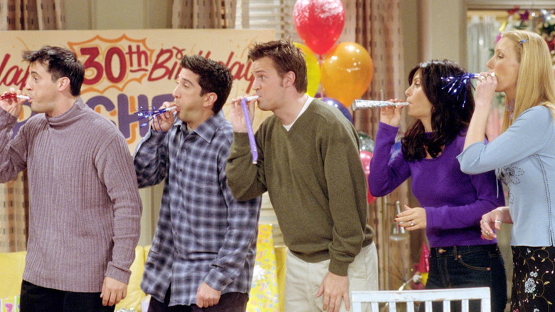 Joey, Ross, Chandler, Monica, and Phoebe blowing party kazoos in Friends