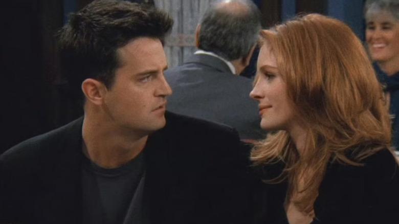 Chandler and his date Suzy sharing a heated glance while seated together at a restaurant in Friends
