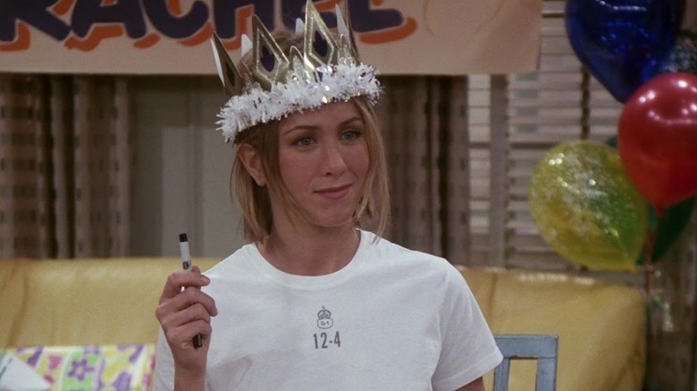 Rachel holding a pen while wearing a party crown at her 30th birthday breakfast in Friends