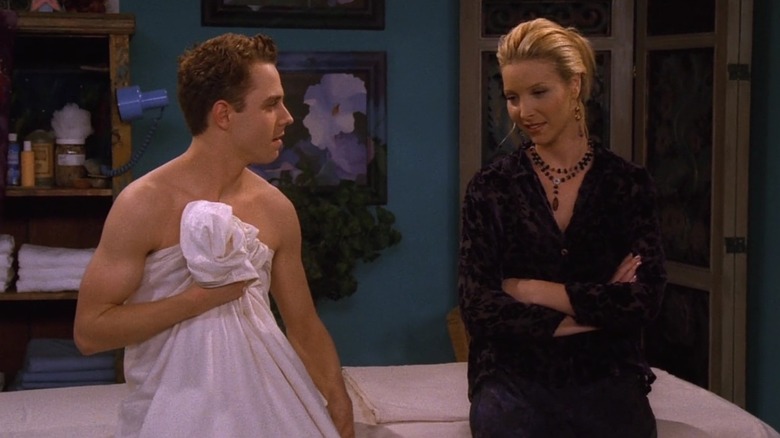 Phoebe's newly discovered brother Frank Jr. sitting naked, wrapped in a sheet, on a massage table and talking with Phoebe in Friends