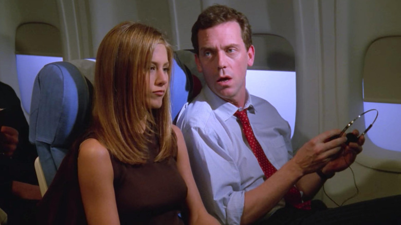 An Englishman in a white shirt and red tie sitting next to Rachel on a plane to London, on Friends