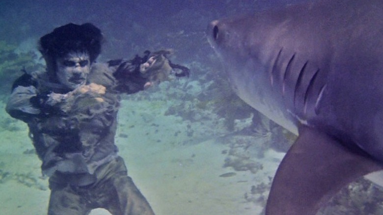 A zombie fighting a shark underwater