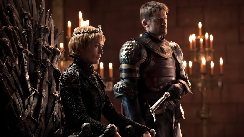 Cersei sits on the Iron Throne with Jaime standing to the right