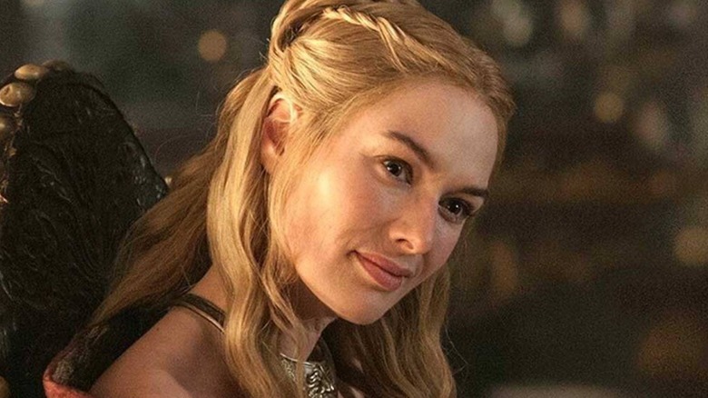 Cersei tilts her head as she listens to someone