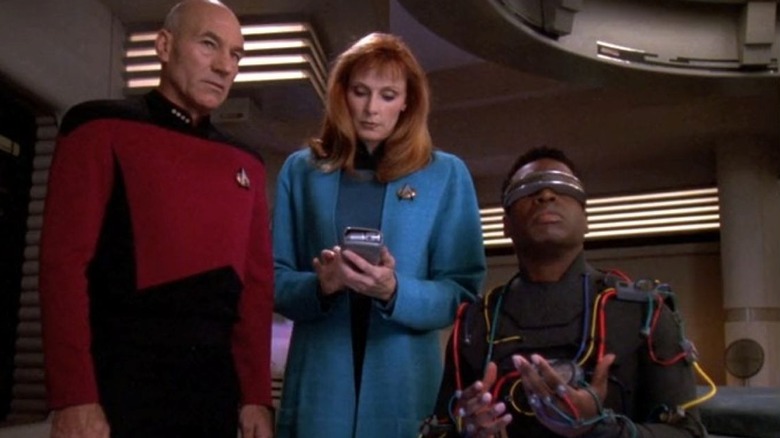 Jean-Luc Picard and Beverly Crusher stand next to Geordi who is wearing interface gear in Star Trek: The Next Generation (1993)