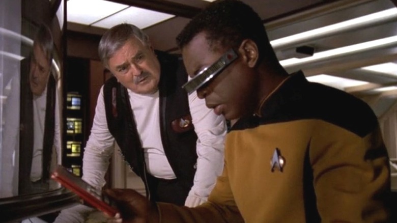 Scotty stands next to Geordi as he works in Star Trek: The Next Generation (1992)