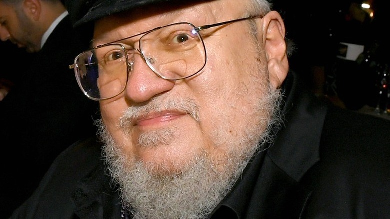 Author George R. R. Martin smiles in a black outfit