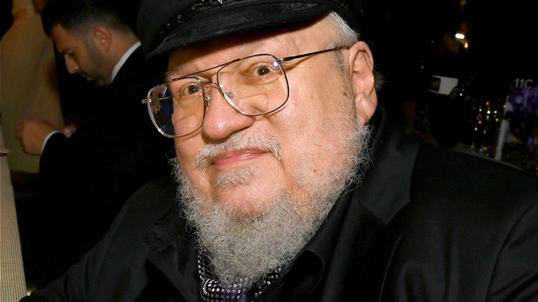 Author George R. R. Martin smiles in a black outfit