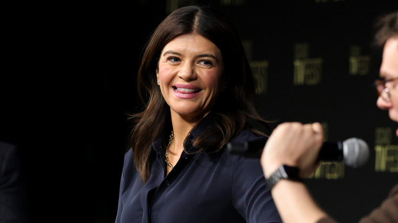 Casey Wilson smiling as she listens to a panel discussion in 2024