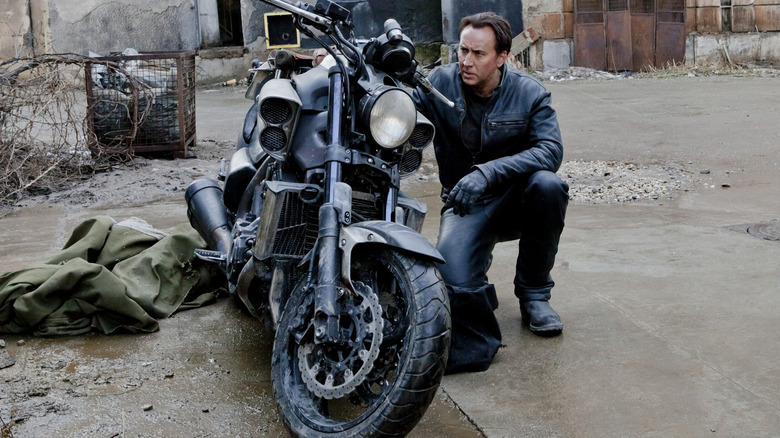 Nicolas Cage looking over motorcycle