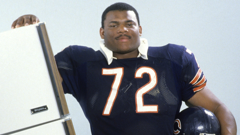 William Perry poses next to refrigerator
