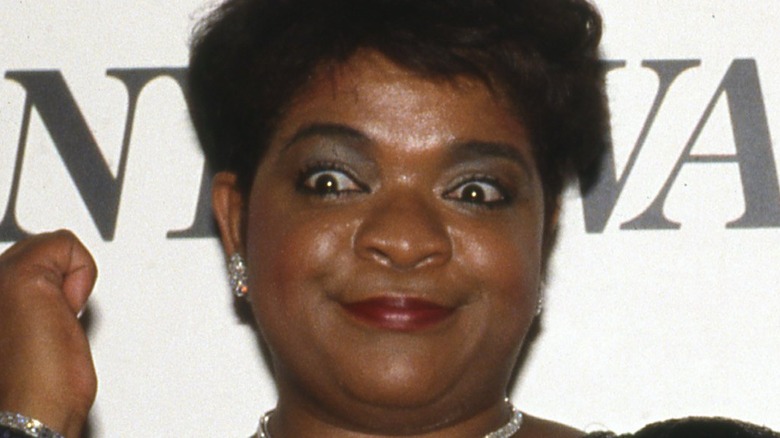 Nell Carter widens her eyes and points to her wrist